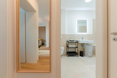 uma casa de banho com um lavatório, um WC e um espelho. em Garden.Lounge Krems am Steinertor em Krems an der Donau