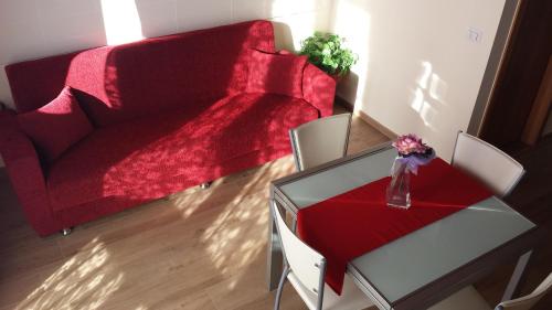 a living room with a red couch and a glass table at Panorama Lucano in Altamura