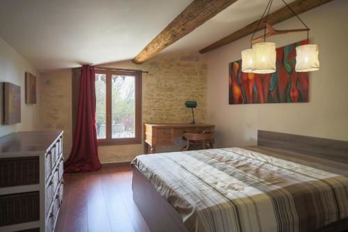 een slaapkamer met een bed, een bureau en een raam bij Mas climatisé à 10 minutes de Montpellier in Lavérune