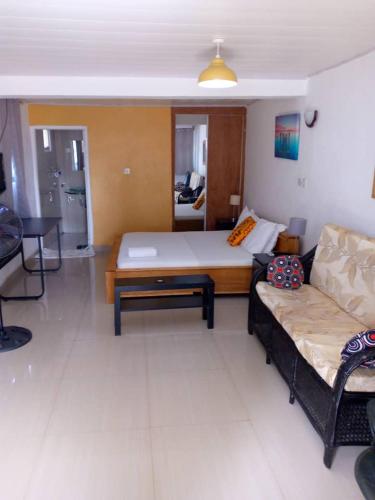 a living room with a bed and a couch at Airport Lodge Lungi in Lungi