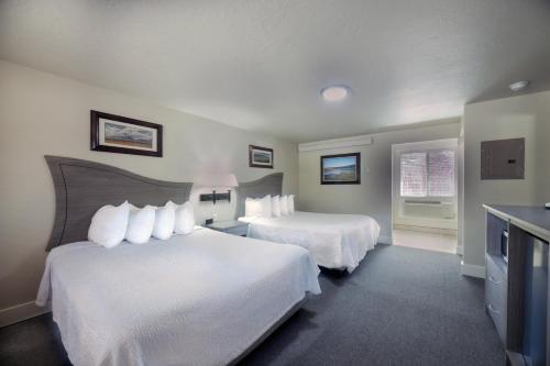 a hotel room with two beds and a television at Flying Saddle Resort and Steak House in Alpine