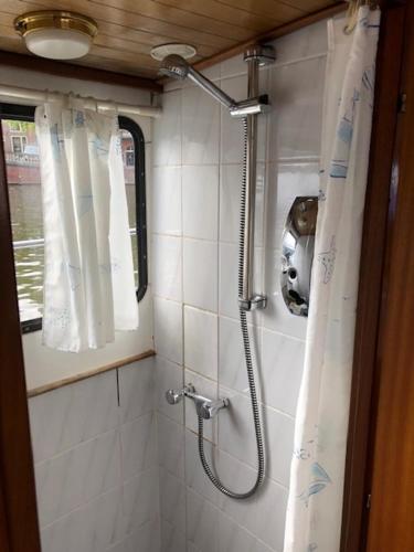 La salle de bains est pourvue d'une douche avec rideau de douche. dans l'établissement Amsterdam Boat & Breakfast, à Amsterdam