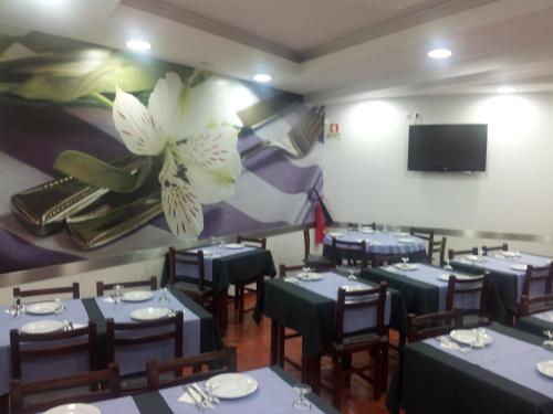 een eetkamer met blauwe tafels en een grote bloem aan de muur bij Residencial Santa Clara in Fátima