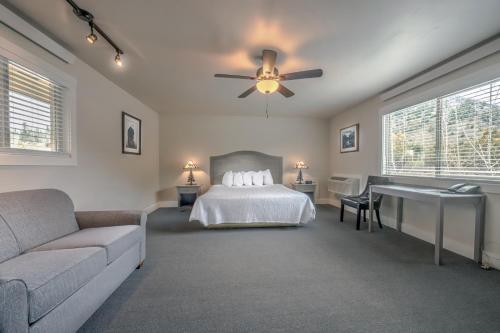 a bedroom with a bed and a couch and a ceiling fan at Flying Saddle Resort and Steak House in Alpine