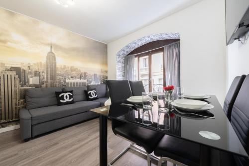 a dining room with a table and a couch at Apartamentos Day Madrid CHUECA Centro Gran Via Sol Malasaña in Madrid