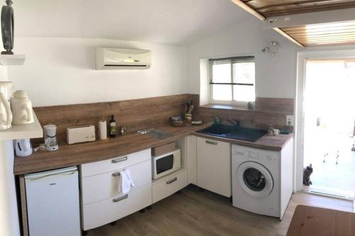 une cuisine avec un évier et une machine à laver dans l'établissement Rez de villa pour 2 personnes près de Santa Giulia, à Sotta