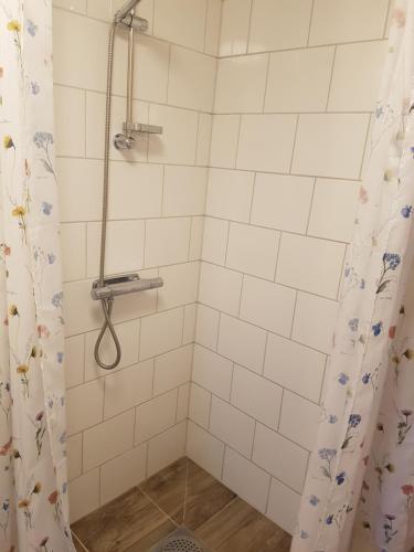 a bathroom with a shower with a shower curtain at Raselund Gård in Vinninga
