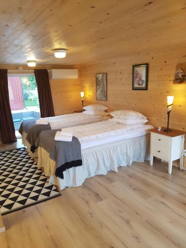a bedroom with two beds in a log cabin at Raselund Gård in Vinninga