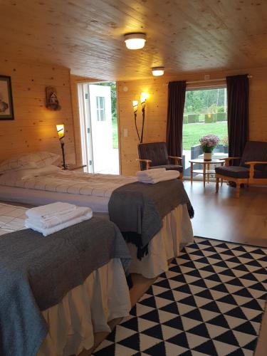 a bedroom with two beds in a log cabin at Raselund Gård in Vinninga