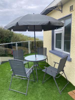 a table and chairs with an umbrella on the grass at The Gaslight Inn Self Catering Holiday Apartments Rossnowlagh Donegal in Rossnowlagh