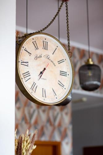 a clock hanging from a chain in a room at HOTEL LEMONIADA in Lućmierz