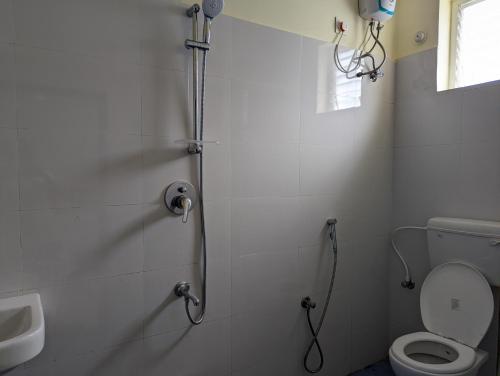 a bathroom with a shower with a toilet and a sink at Ramya Grand in Visakhapatnam
