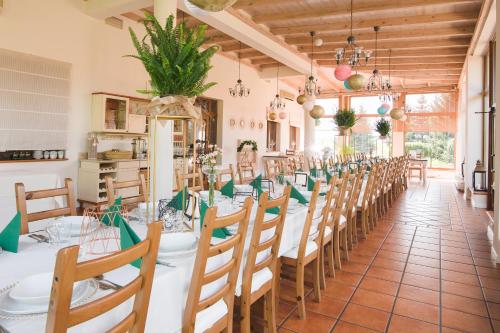 a dining room with a long table and chairs at HOTEL LEMONIADA in Lućmierz