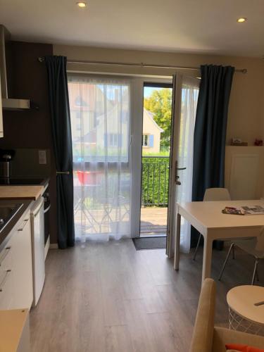 une cuisine avec une table et une porte donnant sur une terrasse. dans l'établissement Quiet Corner, à Colmar