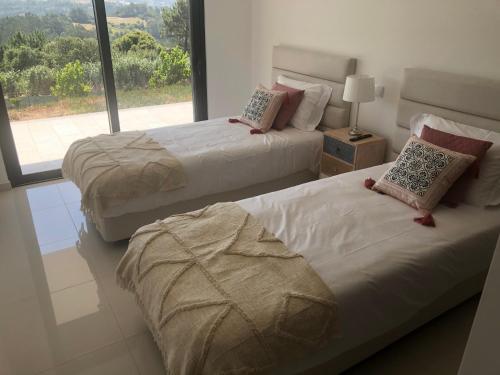 Duas camas num quarto com uma janela grande em Villa White Lagoon, 6 guests, 2 bathrooms, heated private pool, amazing view, fully Equiped ! em Alfeizerão