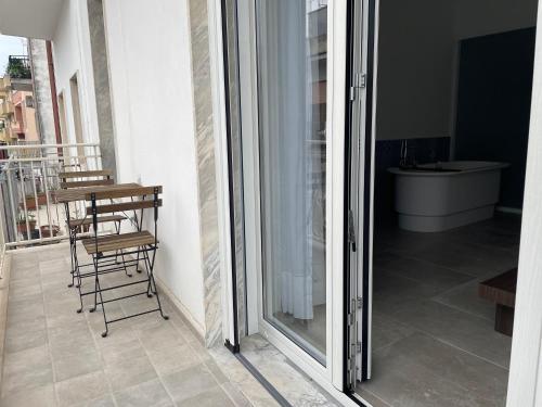 a sliding glass door with a table and chairs on a balcony at Elementi Luxury House in Otranto