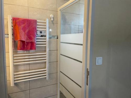 ein Bad mit einer Dusche und einem roten Handtuch in der Unterkunft Les Meublés de Lassou Gîte in Lombers