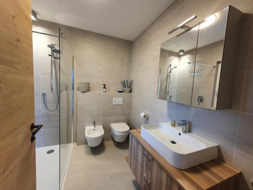 een badkamer met een wastafel, een toilet en een douche bij New Great Apartment Bolzano with 25m pool in Bolzano