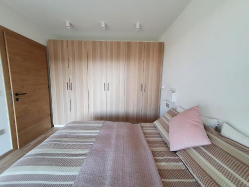 ein Schlafzimmer mit einem großen Bett mit einem rosa Kissen in der Unterkunft New Great Apartment Bolzano with 25m pool in Bozen