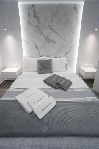 a bed with two pillows and towels on it at A casa nostra in Loutraki