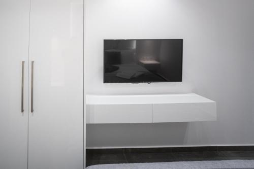 een tv op een witte muur bij A casa nostra in Loutraki