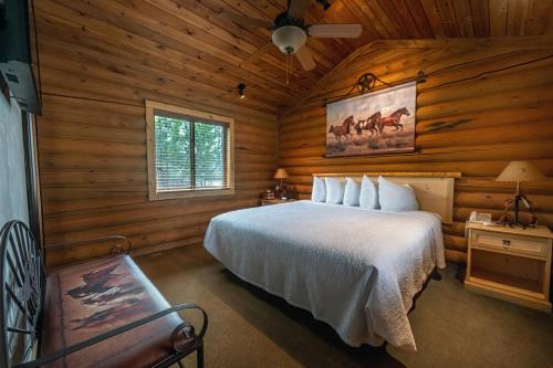 a bedroom with a bed in a log cabin at Flying Saddle Resort and Steak House in Alpine