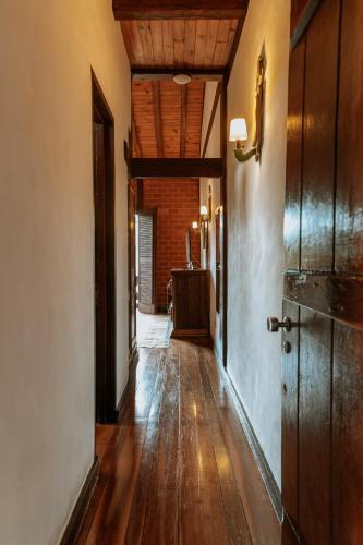 an empty hallway with wood floors and a room with a door at Pousada Pedra Azul in Pedra Azul