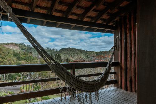 a hammock on a porch with a view of a river at Pousada Pedra Azul in Pedra Azul