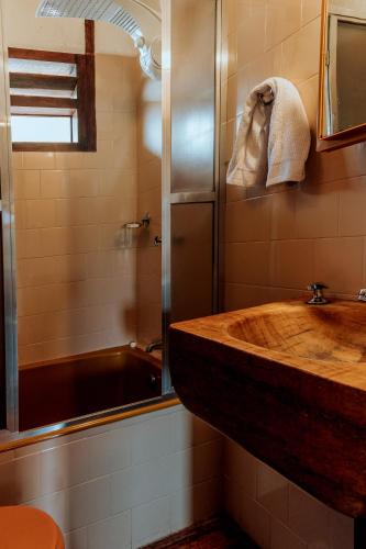 a bathroom with a wooden sink and a shower at Pousada Pedra Azul in Pedra Azul