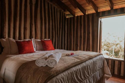 a bedroom with a large bed with towels on it at Pousada Pedra Azul in Pedra Azul