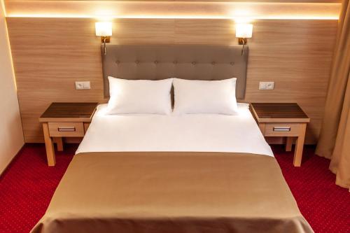 a bedroom with a large bed with two tables at Tourist Chernivtsi in Chernivtsi