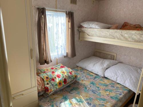 a bedroom with two bunk beds and a window at Domek letniskowy in Giby