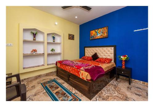 una camera da letto con pareti blu e un letto con lenzuola rosse di Orchha Best Homestay a Orchha