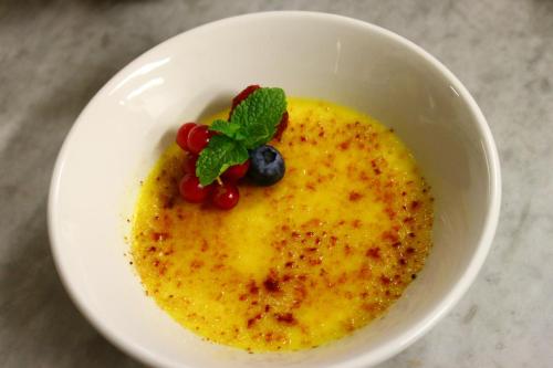 a white bowl with a dessert with berries on it at Alpen Hotel Eghel in Folgaria