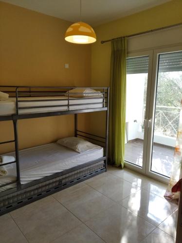a bedroom with two bunk beds and a balcony at Cozy villa Vita Lagonisi in Kalívia Thorikoú