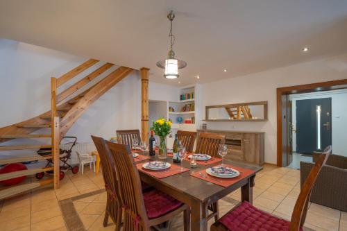 een eetkamer met een houten tafel en stoelen bij Karkonosky Apartamenty- Ściegny in Ściegny