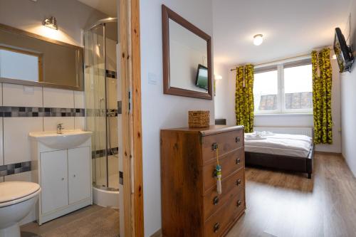 a bathroom with a sink and a toilet and a bed at Karkonosky Apartamenty- Ściegny in Ściegny