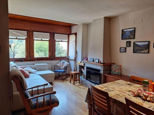 a living room with a couch and a table at Espot Natura - Apartament de muntanya al PN Aigüestortes i Sant Maurici in Espot