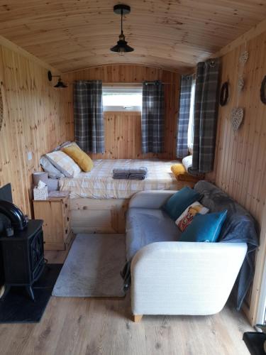 a bedroom with a bed and a couch in a room at Sunset View Shepherds Hut in Dalmally