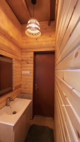 a bathroom with a sink and a wooden wall at كوخ البيلسان in Al Shafa