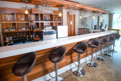 a bar with leather stools in a restaurant at Avenue Hotel Baku by Smart in Baku