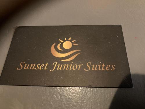 a sign for a sunburst juniper suite on a table at Sunset junior suites in Agios Ioannis Tinos