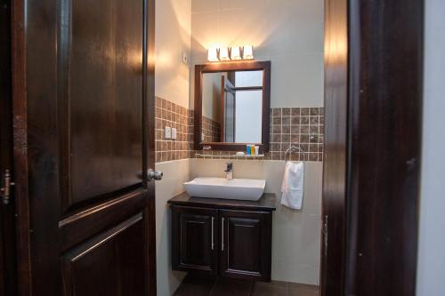 a bathroom with a sink and a mirror at The Highbridge Guest Lodge in Accra