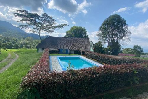 una piscina en un patio con un edificio en Confortable cabaña para que disfrute con su pareja, en Santandercito