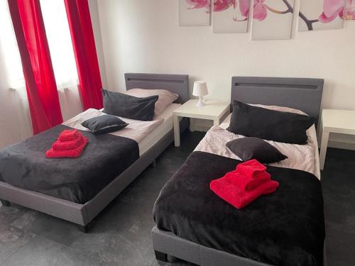 Dos camas en una habitación con toallas rojas. en Ferienwohnungen Calwer Höfle Marktplatz - für Firmen, Handwerker und Monteure, en Calw