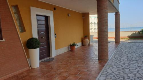 een huis met een bruine deur en een bakstenen vloer bij Tramonto Sul Mare in Termoli