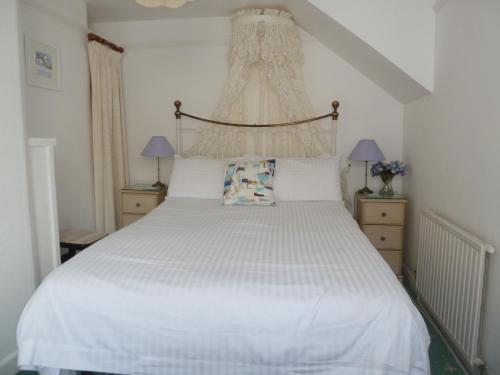 a bedroom with a bed with a white bedspread at Grey Mullet Guesthouse in St Ives