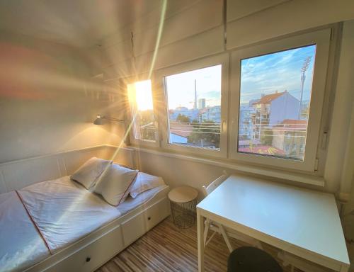 een kleine kamer met een bed en 2 ramen bij Studio Cibona in Zagreb