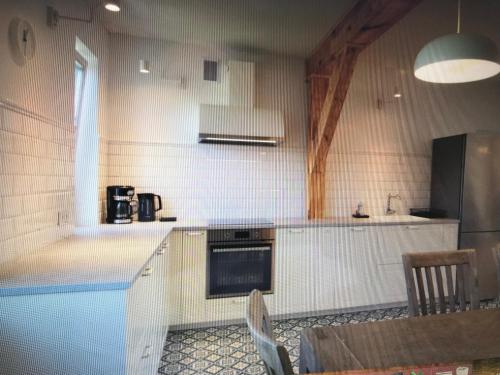 a kitchen with a table and a stove and a refrigerator at Marymont Metro Apartment in Warsaw