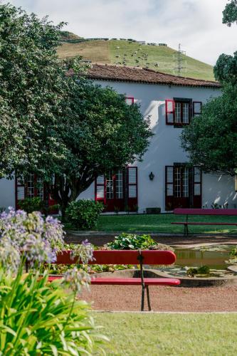 a red bench in front of a white building at Monte Ingles in Ponta Delgada